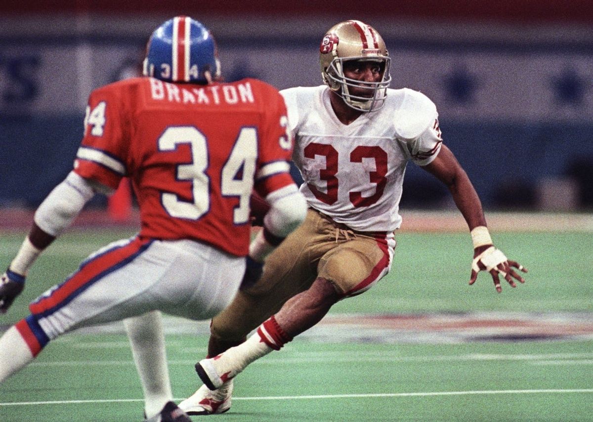 Jan 28, 1990; New Orleans, LA, USA; FILE PHOTO; San Francisco 49ers running back Roger Craig (33) carries the ball against Denver Broncos cornerback Tyrone Braxton (34) during Super Bowl XXIV at the Superdome. The 49ers defeated the Broncos 55-10. Mandatory Credit: Darr Beiser-Imagn Images