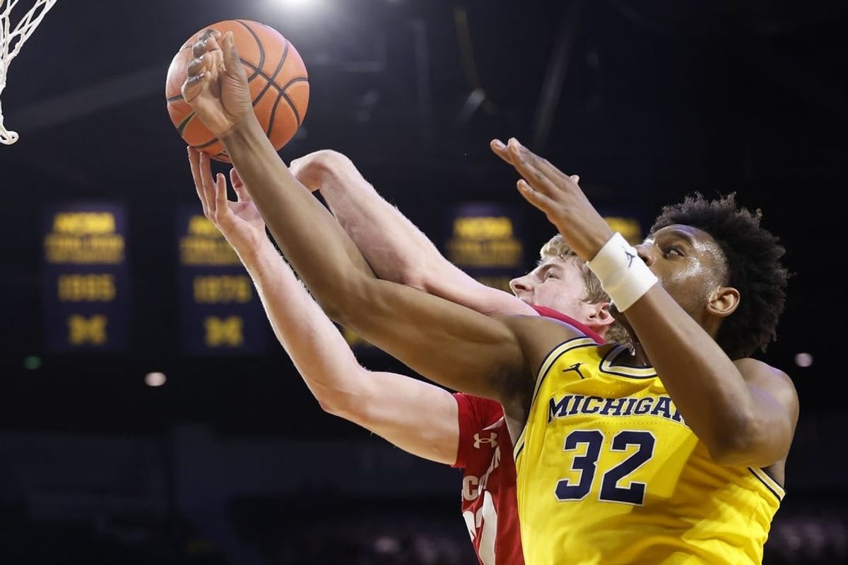 Feb 7, 2024; Ann Arbor, Michigan, USA; Wisconsin Badgers forward Steven Crowl (22) and Michigan Wolverines forward Tarris Reed Jr. (32) go for the rebound in the first half at Crisler Center.
