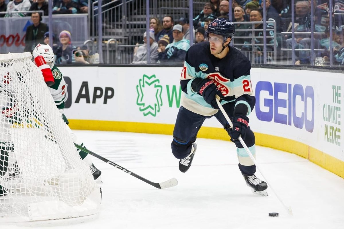 Feb 24, 2024; Seattle, Washington, USA; Seattle Kraken center Alex Wennberg (21) skates with the puck behind the net against the Minnesota Wild during the third period at Climate Pledge Arena.