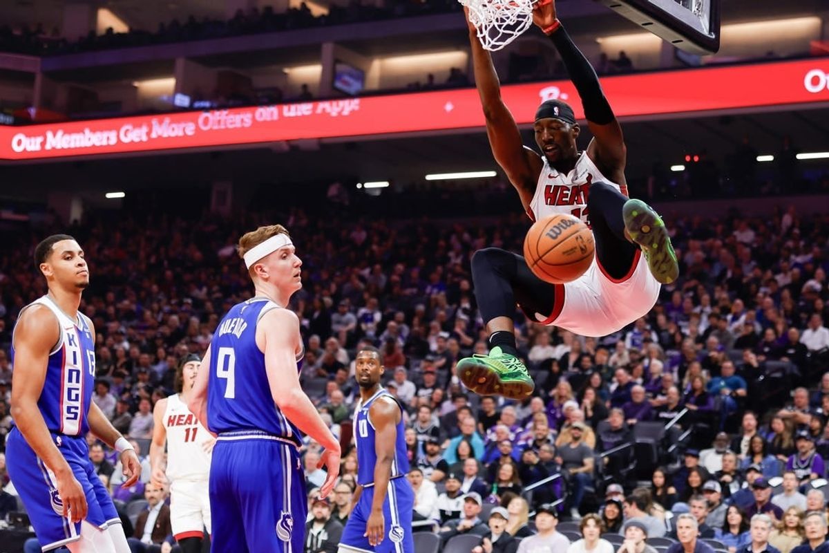 Feb 26, 2024; Sacramento, California, USA; Miami Heat center Bam Adebayo (13) dunks the ball against Sacramento Kings guard Kevin Huerter (9) during the first quarter at Golden 1 Center.