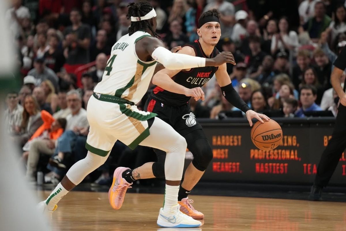 Feb 11, 2024; Miami, Florida, USA;  Miami Heat guard Tyler Herro (14) dribbles the ball against Boston Celtics guard Jrue Holiday (4) defends during the second half at Kaseya Center.