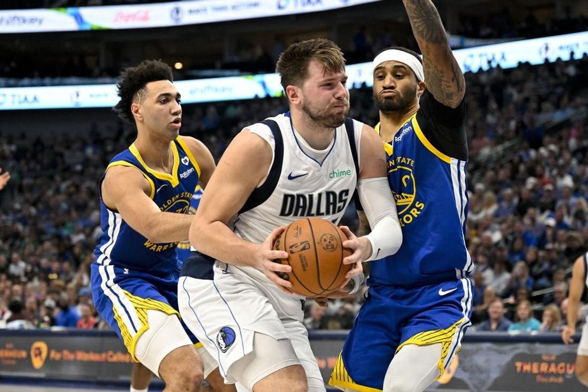 Mar 13, 2024; Dallas, Texas, USA; Dallas Mavericks guard Luka Doncic (77) drives to the basket past Golden State Warriors forward Trayce Jackson-Davis (32) and guard Gary Payton II (0) during the first half at the American Airlines Center.