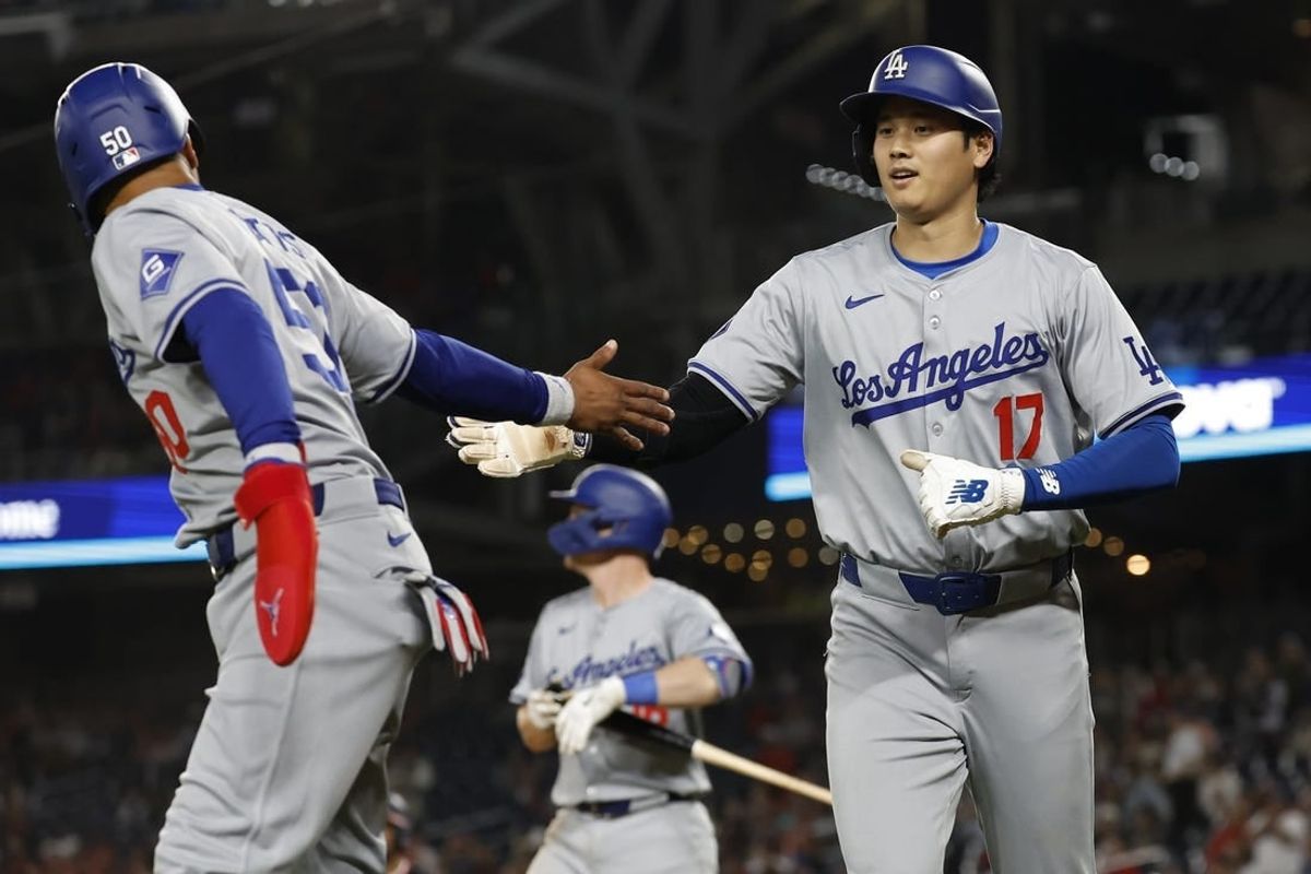 Apr 24, 2024; Washington, District of Columbia, USA; Los Angeles Dodgers shortstop Mookie Betts (50) and Dodgers designated hitter Shohei Ohtani (17) celebrate after scoring runs on a single by Dodgers first baseman Freddie Freeman (not pictured) against the Washington Nationals during the ninth inning at Nationals Park.