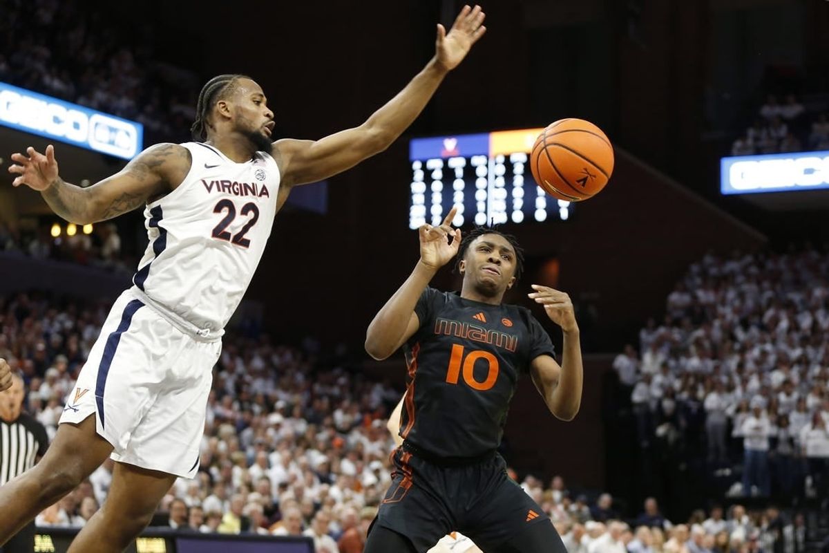 Feb 5, 2024; Charlottesville, Virginia, USA; Virginia Cavaliers forward Jordan Minor (22) knocks the ball away from Miami (Fl) Hurricanes guard Paul Djobet (10) during the first half at John Paul Jones Arena.