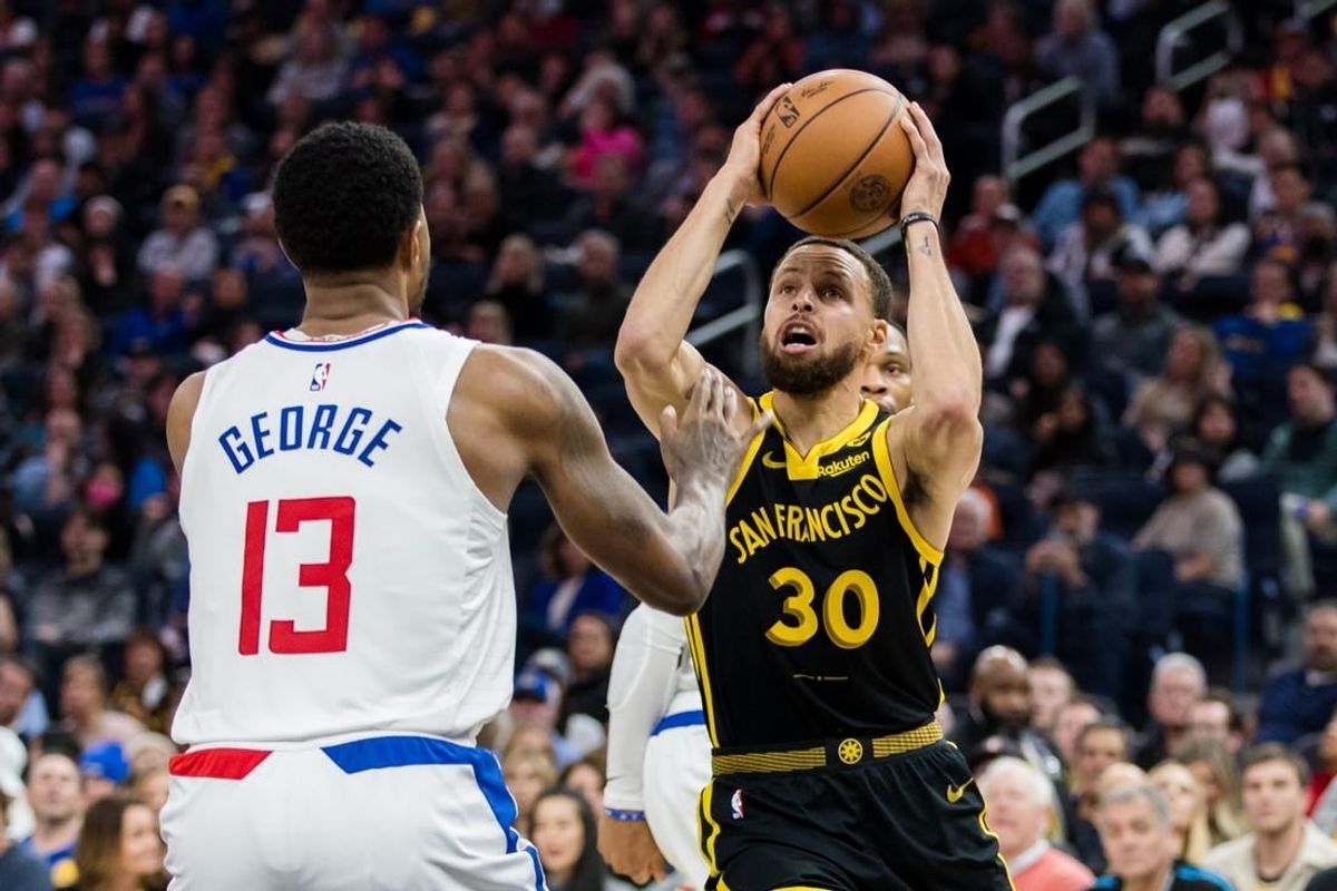 Feb 14, 2024; San Francisco, California, USA; Golden State Warriors guard Stephen Curry (30) passes over LA Clippers forward Paul George (13) during the first half at Chase Center.