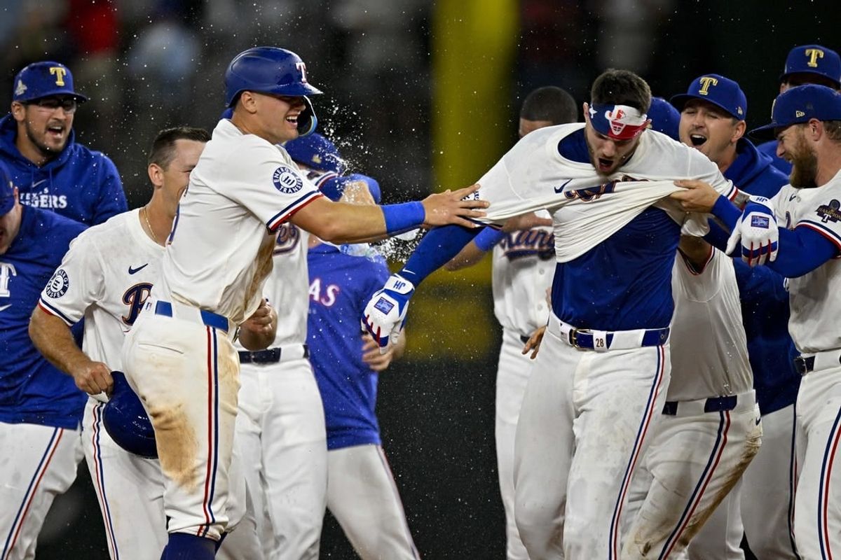 Mar 31, 2024; Arlington, Texas, USA; Texas Rangers catcher Jonah Heim (28) and third baseman Josh Jung (6) celebrate after Heim hits a walk off single against the Chicago Cubs during the tenth inning at Globe Life Field.
