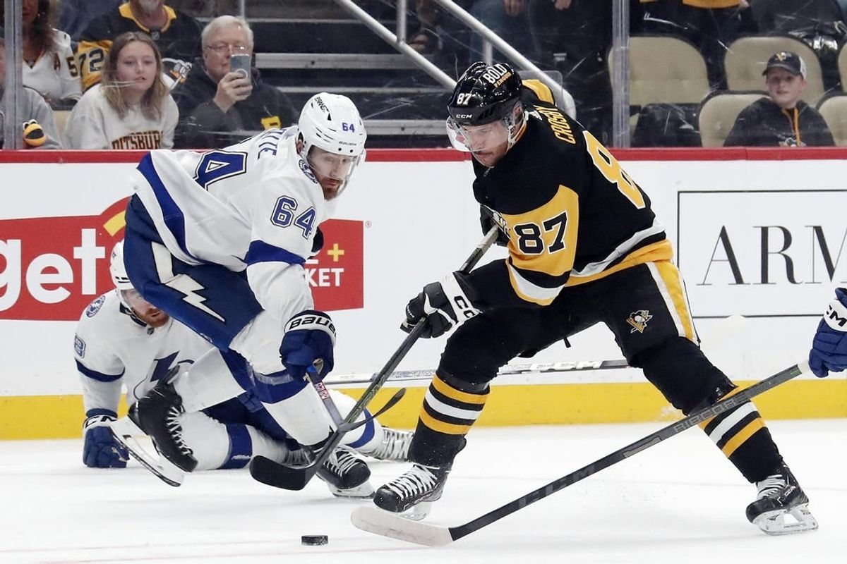 Apr 6, 2024; Pittsburgh, Pennsylvania, USA;  Pittsburgh Penguins center Sidney Crosby (87) moves the puck against Tampa Bay Lightning center Tyler Motte (64) during the first period at PPG Paints Arena.