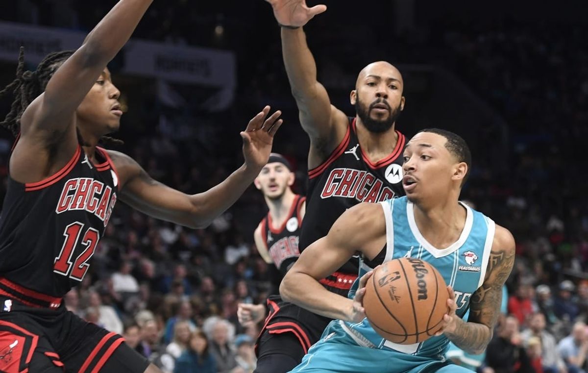 Jan 8, 2024; Charlotte, North Carolina, USA;  Charlotte Hornets guard Nick Smith Jr. (8) looks to shoot as he is defended by Chicago Bulls guard Aye Dosunmu (12) and guard Jevon Carter (5) during the first half at the Spectrum Center.