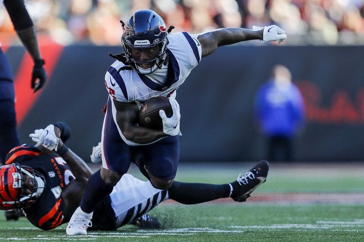 Nov 12, 2023; Cincinnati, Ohio, USA; Houston Texans running back Mike Boone (22) runs with the ball against Cincinnati Bengals cornerback Mike Hilton (21) in the first half at Paycor Stadium.