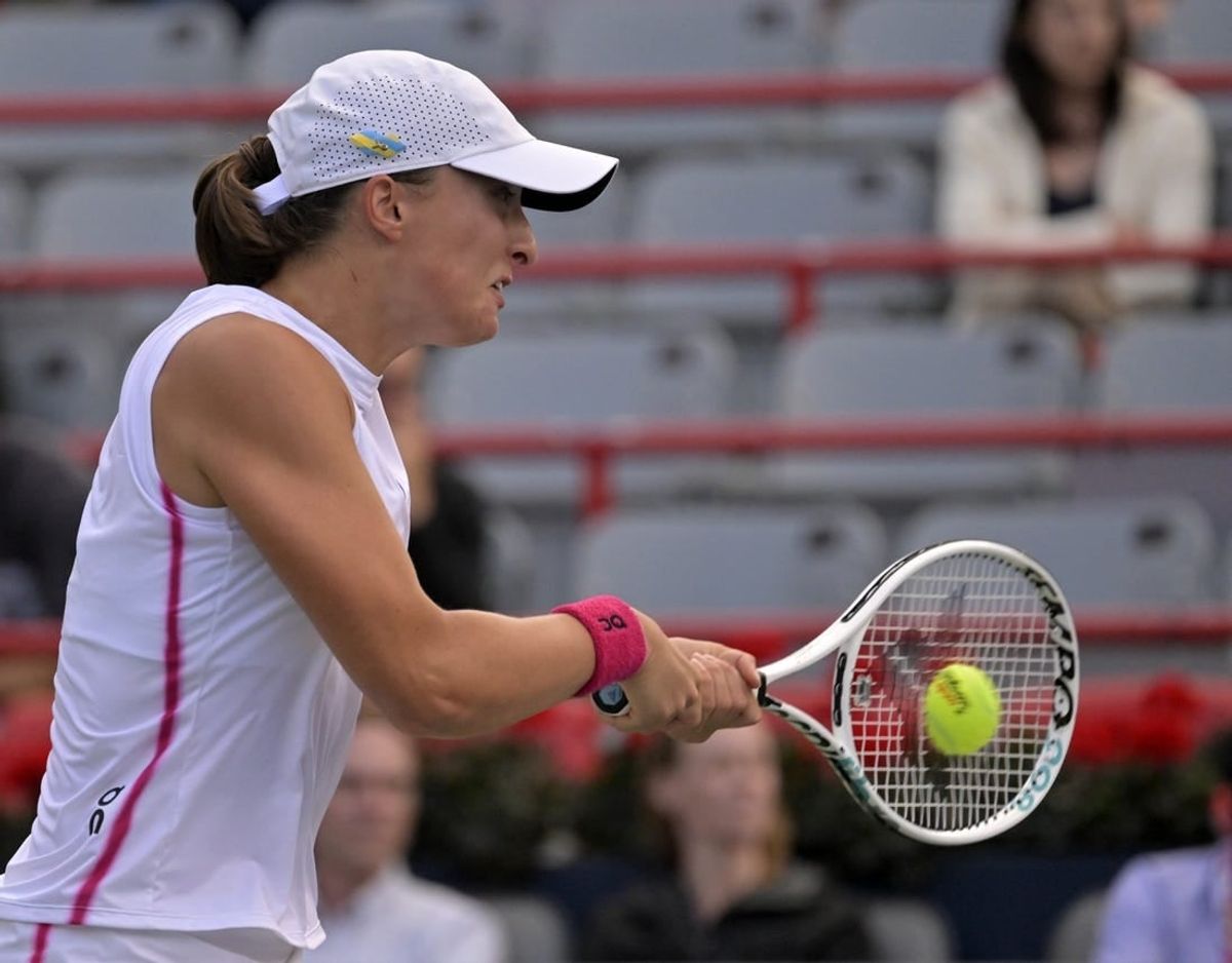 Aug 11, 2023; Montreal, Quebec, Canada; Iga Swiatek (POL) hits a backhand against Danielle Collins (USA) (not pictured) during quarterfinal play at IGA Stadium.