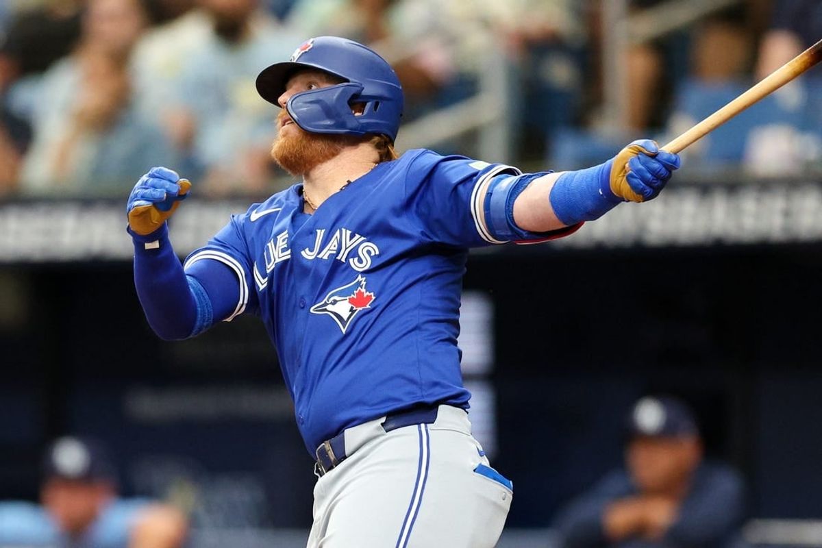 Mar 31, 2024; St. Petersburg, Florida, USA;  Toronto Blue Jays third baseman Justin Turner (2) hits a solo home run against the Tampa Bay Rays in the fifth inning at Tropicana Field.