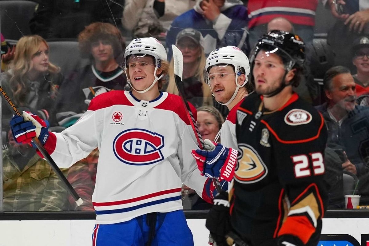 Nov 22, 2023; Anaheim, California, USA; Montreal Canadiens defenseman Kaiden Guhle (21) and left wing Michael Pezzetta (55) celebrate after a goal as Anaheim Ducks center Mason McTavish (23) reacts in the first period at Honda Center.