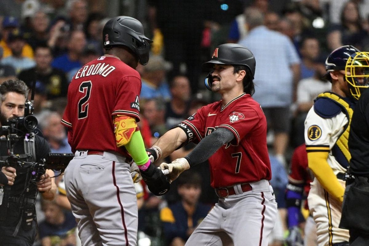 Oct 3, 2023; Milwaukee, Wisconsin, USA; Arizona Diamondbacks shortstop Geraldo Perdomo (2) and left fielder Corbin Carroll (7) celebrate scoring in the third inning against the Milwaukee Brewers during game one of the Wildcard series for the 2023 MLB playoffs at American Family Field.