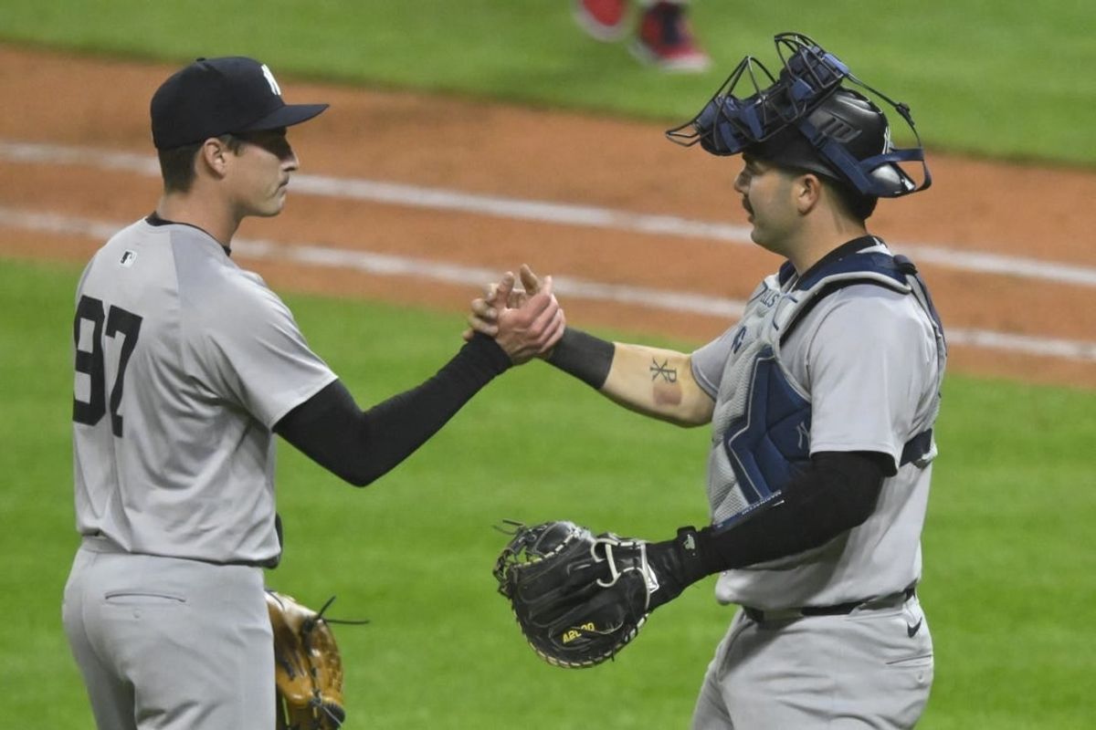 Apr 13, 2024; Cleveland, Ohio, USA; New York Yankees relief pitcher Ron Marinaccio (97) and catcher Austin Wells (28) celebrate a win over the Cleveland Guardians at Progressive Field.