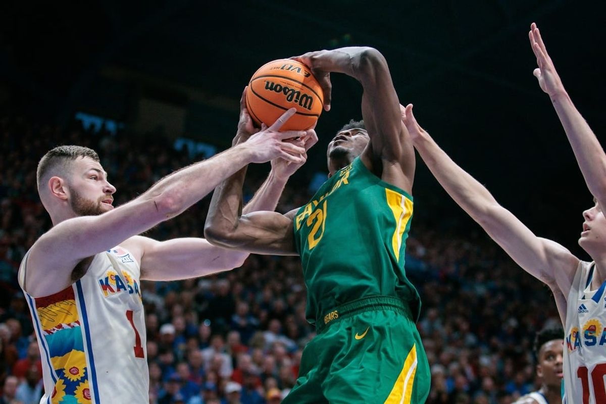 Feb 10, 2024; Lawrence, Kansas, USA; Baylor Bears center Yves Missi (21) gets tangled up with Kansas Jayhawks center Hunter Dickinson (1) under the basket during the first half at Allen Fieldhouse.