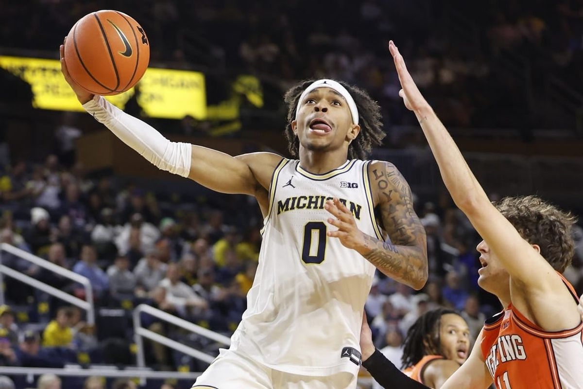 Jan 18, 2024; Ann Arbor, Michigan, USA;  Michigan Wolverines guard Dug McDaniel (0) shoots on Illinois Fighting Illini guard Niccolo Moretti (11) in the first half at Crisler Center.