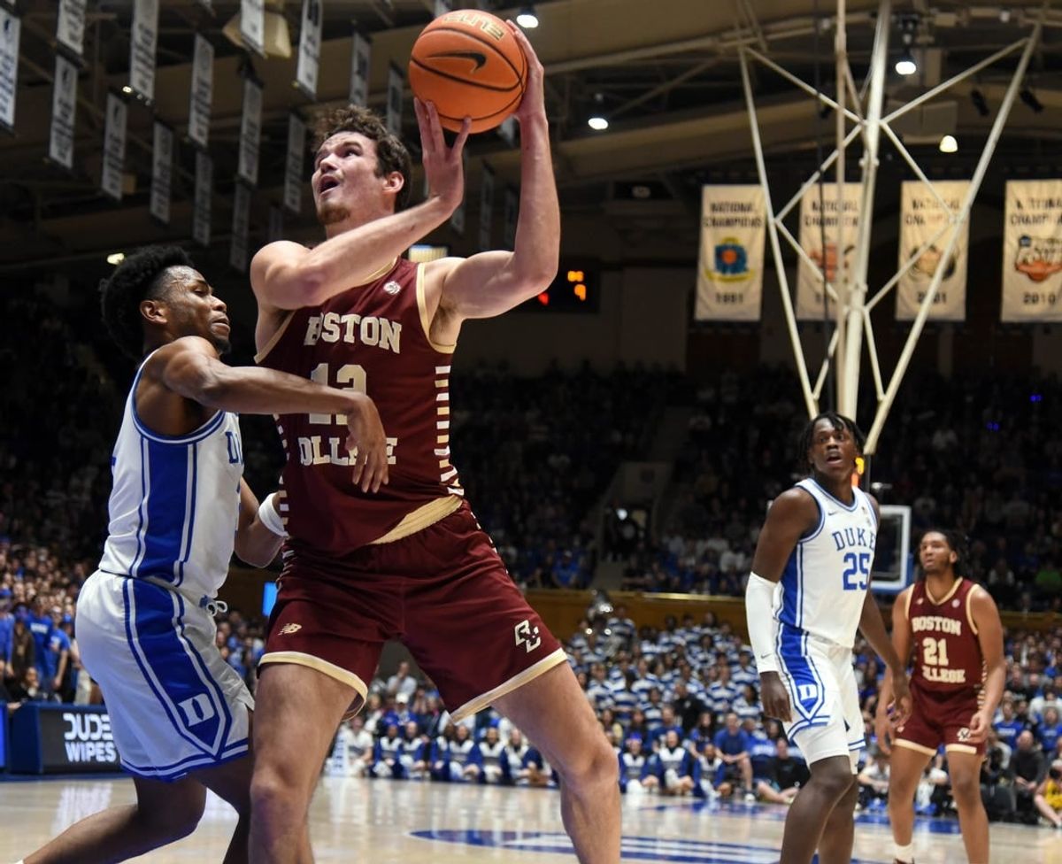 Feb 10, 2024; Durham, North Carolina, USA; Boston College Eagles center Quinten Post (12) shoots the ball over Duke Blue Devils guard Jeremy Roach (left) during the first half  at Cameron Indoor Stadium.