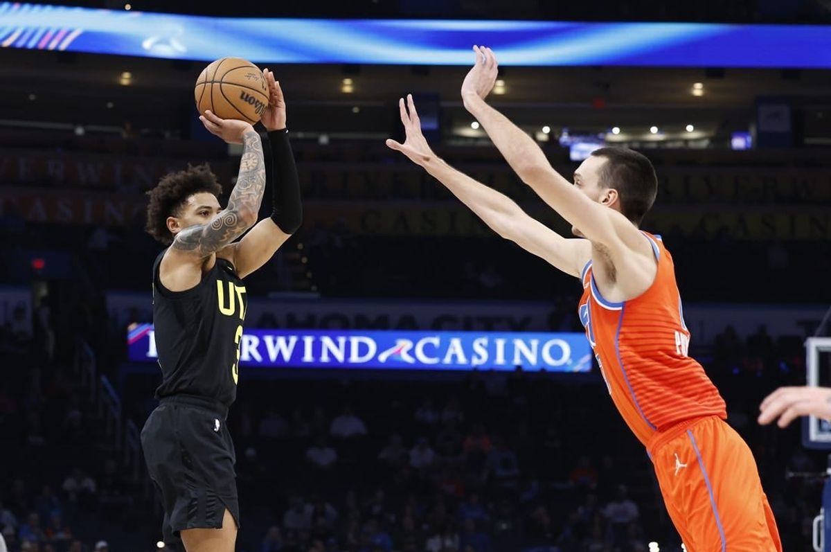 Dec 11, 2023; Oklahoma City, Oklahoma, USA; Utah Jazz guard Keyonte George (3) shoot a three-point basket as Oklahoma City Thunder forward Aleksej Pokusevski (17) defends during the second half at Paycom Center.