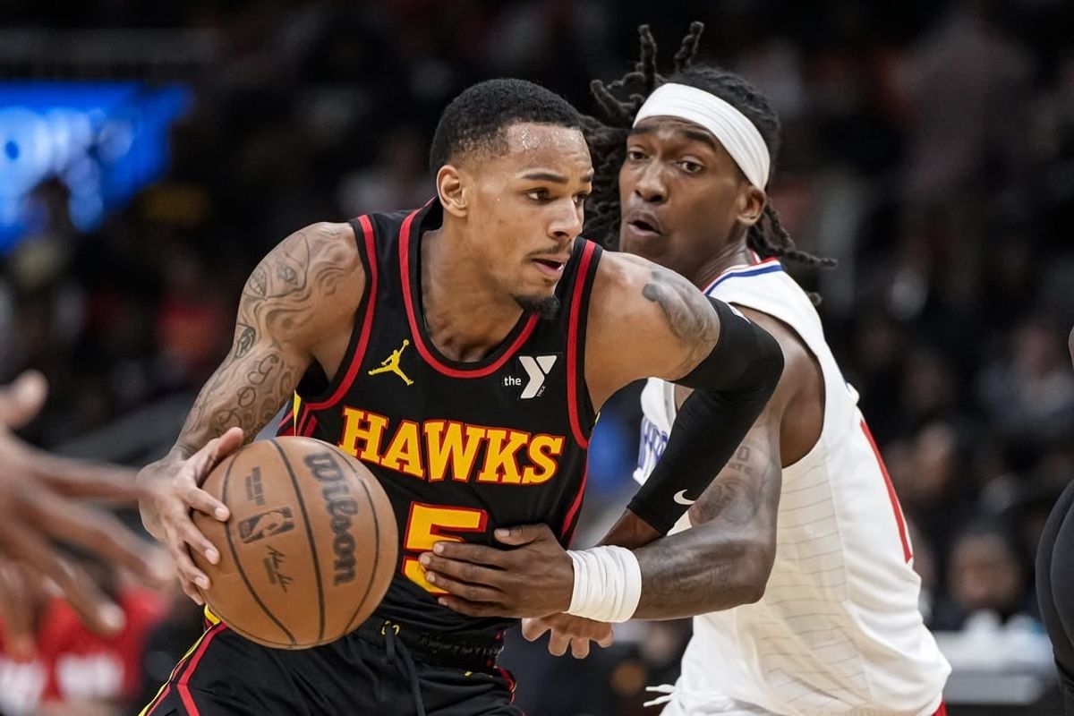 Feb 5, 2024; Atlanta, Georgia, USA; Atlanta Hawks guard Dejounte Murray (5) dribbles past LA Clippers guard Terance Mann (14) during the first half at State Farm Arena.