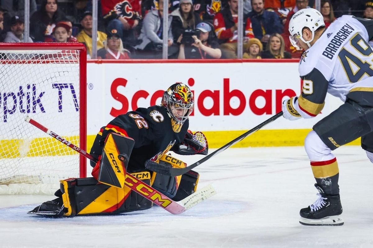 Mar 14, 2024; Calgary, Alberta, CAN; Calgary Flames goaltender Dustin Wolf (32) makes a save against Vegas Golden Knights center Ivan Barbashev (49) during the third period at Scotiabank Saddledome.