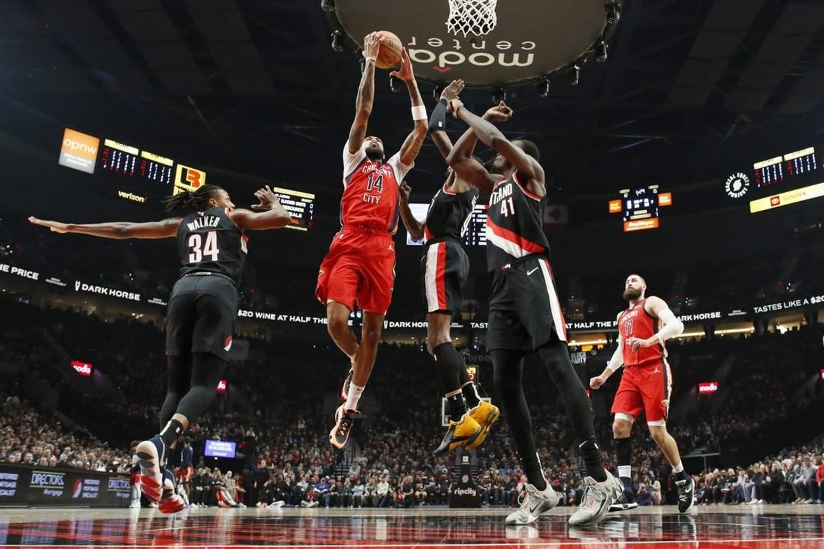Feb 10, 2024; Portland, Oregon, USA; New Orleans Pelicans small forward Brandon Ingram (14) drives for the basket between Portland Trail Blazers forward Jabari Walker (34) and small forward Jerami Grant (9, right) during the first half at Moda Center.