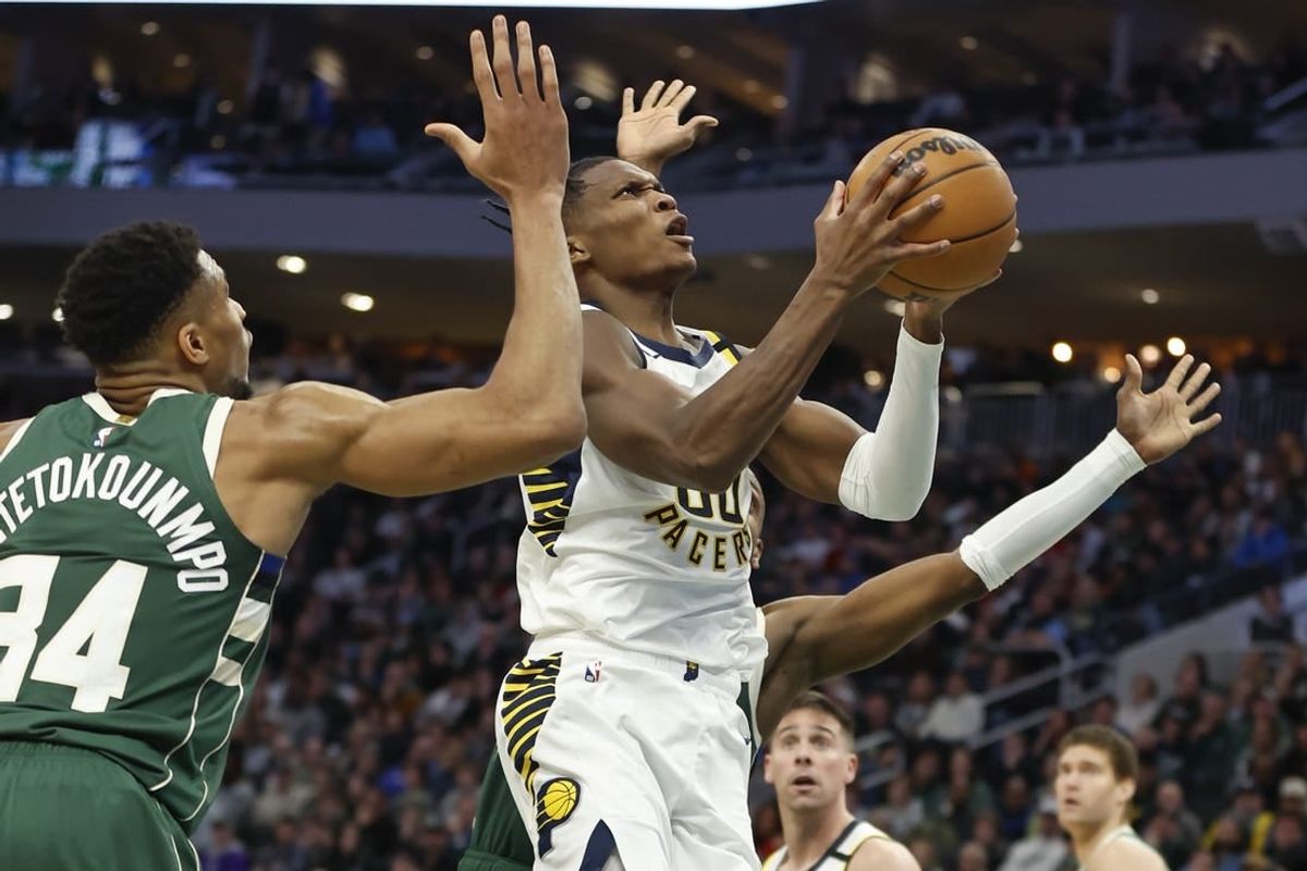 Jan 1, 2024; Milwaukee, Wisconsin, USA; Indiana Pacers guard Bennedict Mathurin (00) goes to the basket against Milwaukee Bucks forward Giannis Antetokounmpo (34) during the second half at Fiserv Forum.