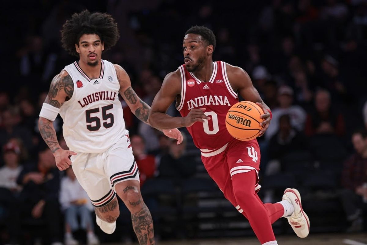 Nov 20, 2023; New York, NY, USA; Indiana Hoosiers guard Xavier Johnson (0) dribbles up court in front of Louisville Cardinals guard Skyy Clark (55) during the second half at Madison Square Garden.