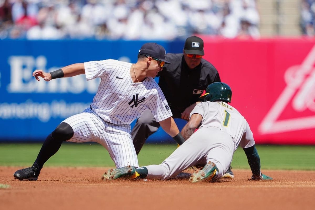 Apr 22, 2024; Bronx, New York, USA; Oakland Athletics left fielder Esteury Ruiz (1) is tagged out while attempting to steal second base against New York Yankees shortstop Anthony Volpe (11) during the first inning at Yankee Stadium.