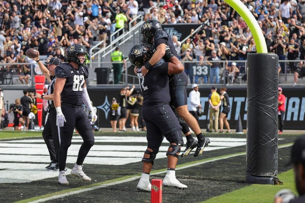 Nov 25, 2023; Orlando, Florida, USA; UCF Knights quarterback John Rhys Plumlee (10) is lifted into the air by offensive lineman Marcellus Marshall (72) after scoring against the Houston Cougars during the first quarter at FBC Mortgage Stadium.