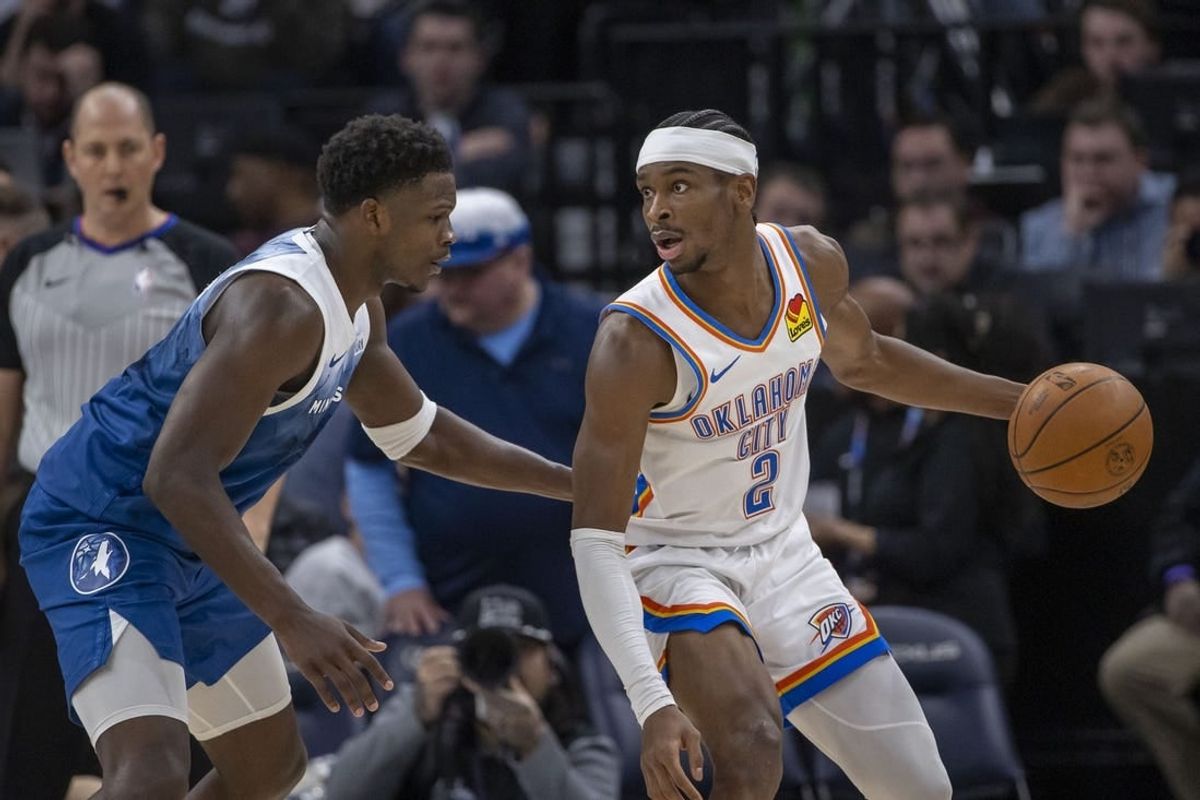Jan 20, 2024; Minneapolis, Minnesota, USA; Oklahoma City Thunder guard Shai Gilgeous-Alexander (2) looks to pass the ball as Minnesota Timberwolves guard Anthony Edwards (5) plays defense in the second half at Target Center.