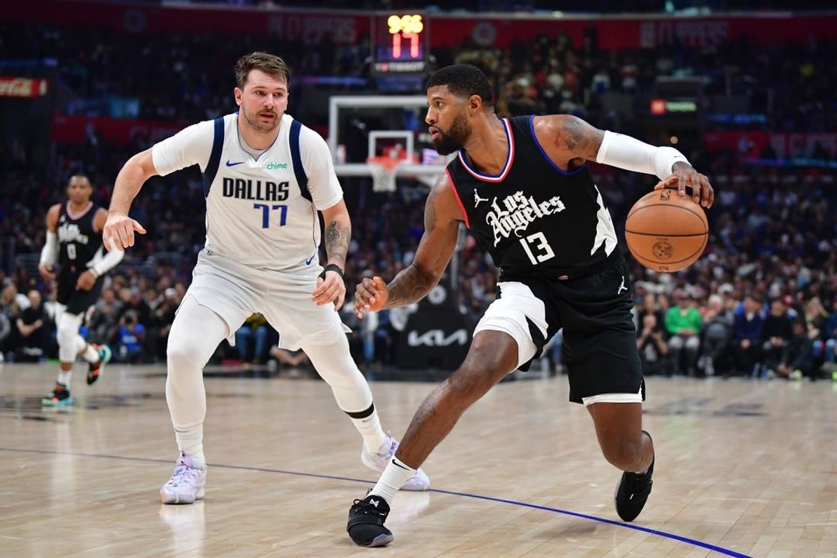 Nov 25, 2023; Los Angeles, California, USA; Los Angeles Clippers forward Paul George (13) moves the ball against Dallas Mavericks guard Luka Doncic (77) during the first half at Crypto.com Arena.