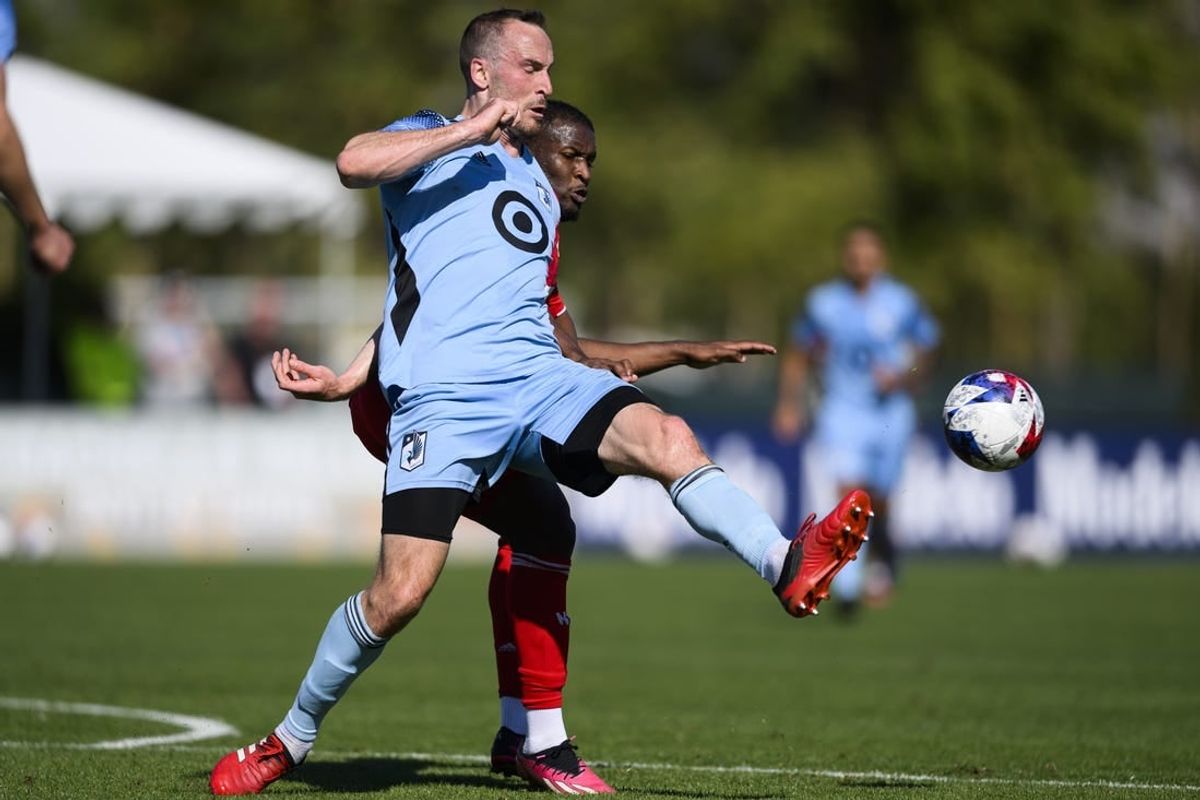 Feb 11, 2023; Indio, CA, USA; Minnesota United Brent Kallman (14) kicks the ball away from New York Red Bulls Elias Manoel (11) at Empire Polo Club.