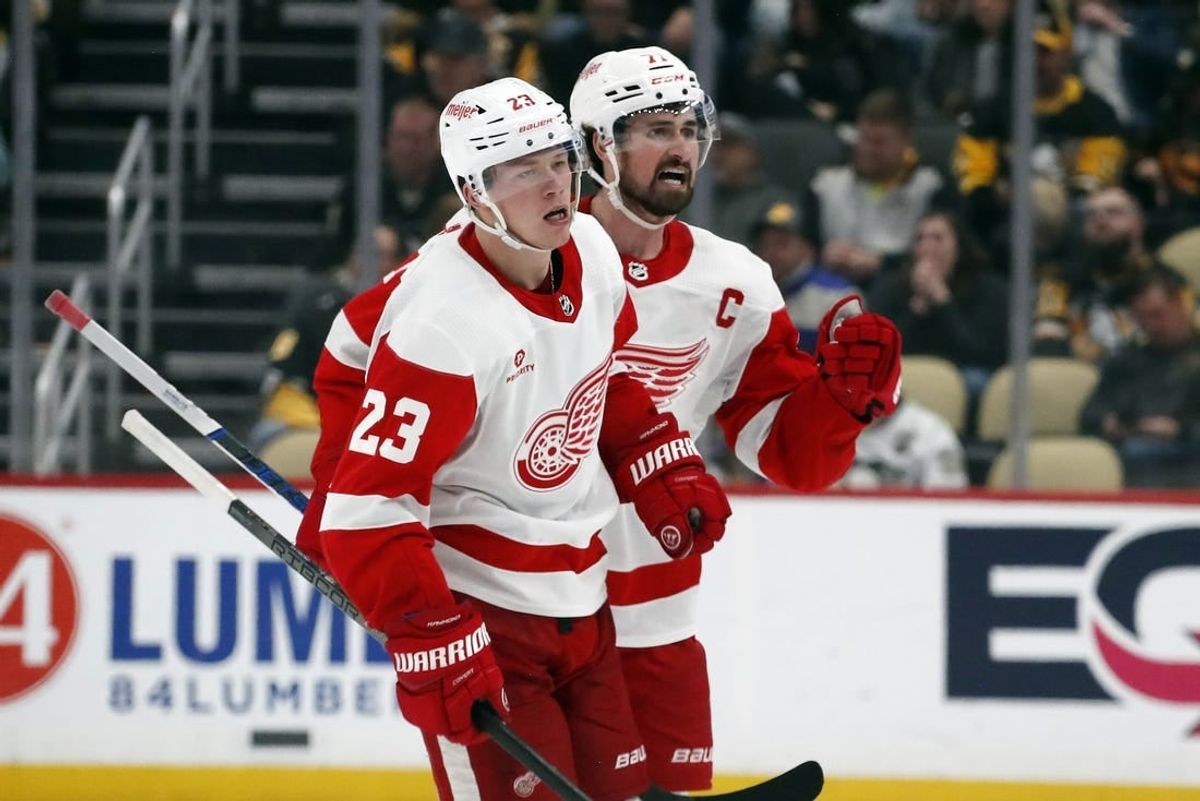 Apr 11, 2024; Pittsburgh, Pennsylvania, USA; Detroit Red Wings left wing Lucas Raymond (23) and center Dylan Larkin (71) celebrate after Raymond scored a goal to complete a hat-trick against the Pittsburgh Penguins during the third period at PPG Paints Arena. Pittsburgh won 6-5 in overtime.