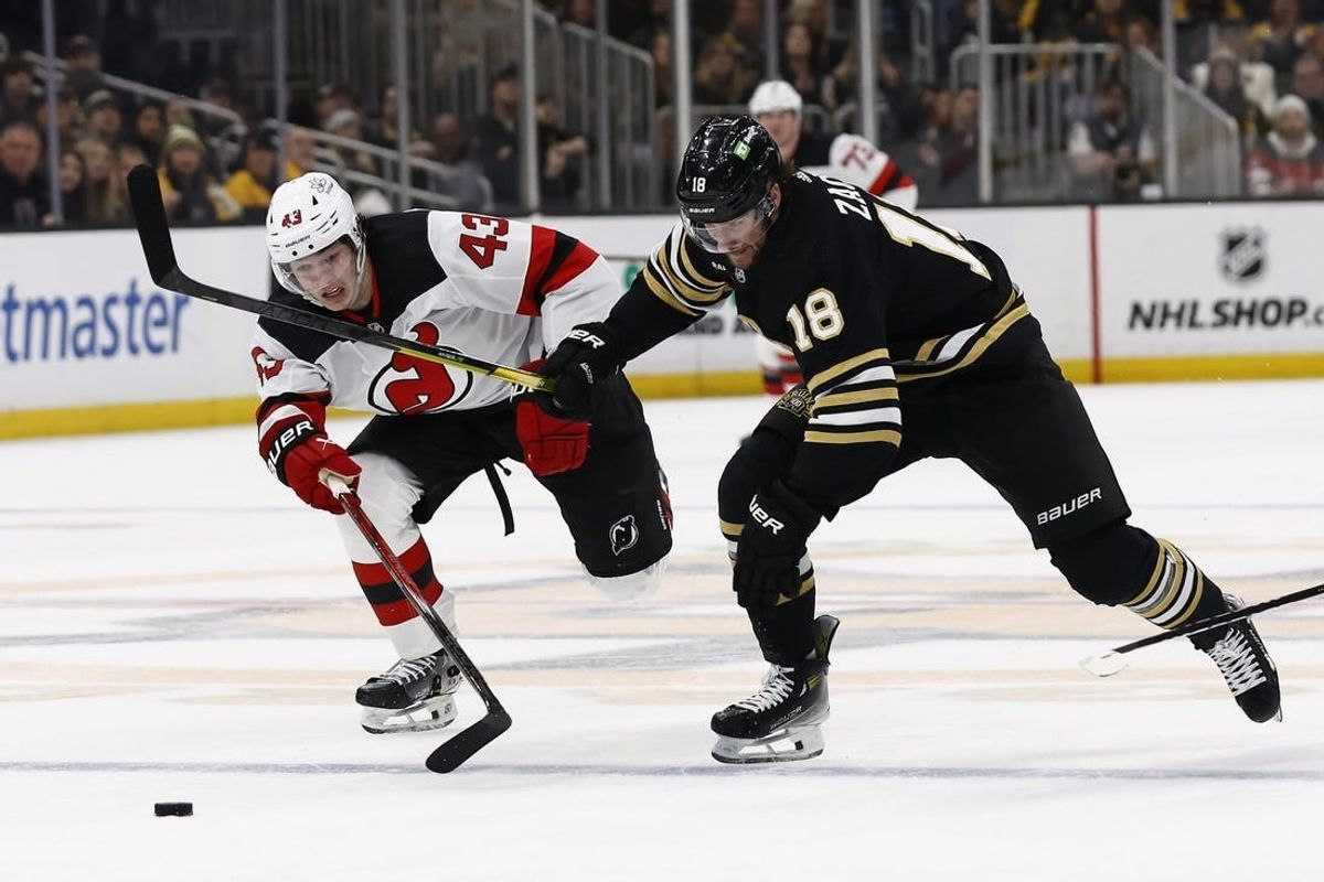 Dec 30, 2023; Boston, Massachusetts, USA; Boston Bruins center Pavel Zacha (18) races New Jersey Devils defenseman Luke Hughes (43) for a loose puck during the first period at TD Garden.