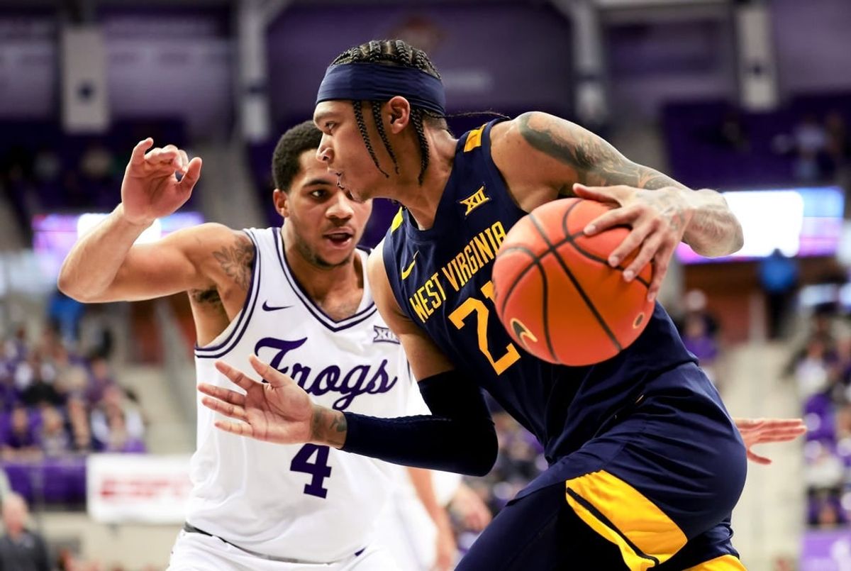 Feb 12, 2024; Fort Worth, Texas, USA;  West Virginia Mountaineers guard RaeQuan Battle (21) drives to the basket as TCU Horned Frogs guard Jameer Nelson Jr. (4) defends during the second half at Ed and Rae Schollmaier Arena.