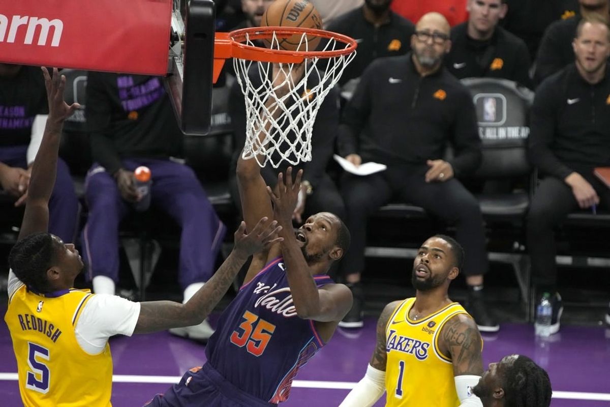 Nov 10, 2023; Phoenix, Arizona, USA; Phoenix Suns forward Kevin Durant (35) scores between Los Angeles Lakers forward Cam Reddish (5) and guard D'Angelo Russell (1) in the first half at Footprint Center.