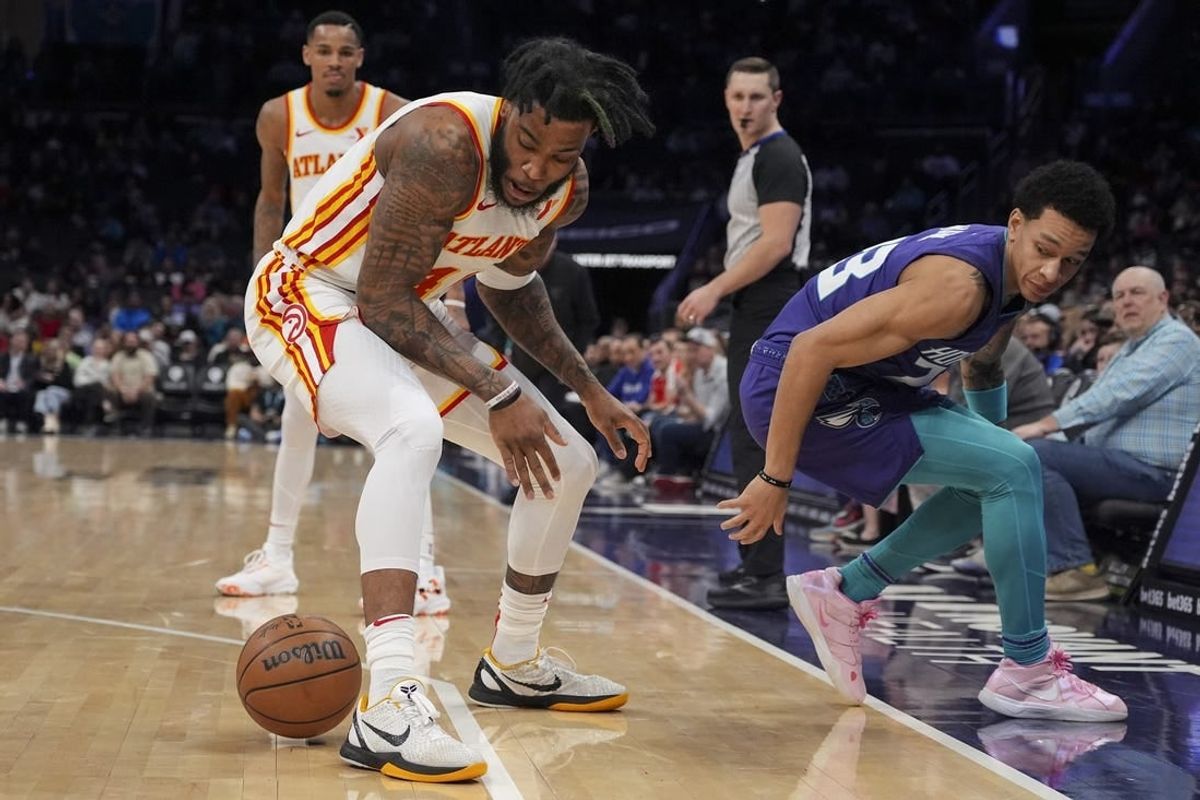 Feb 14, 2024; Charlotte, North Carolina, USA; Atlanta Hawks forward Saddiq Bey (41) loses the ball defended by Charlotte Hornets guard Tre Mann (23) during the second quarter at Spectrum Center.