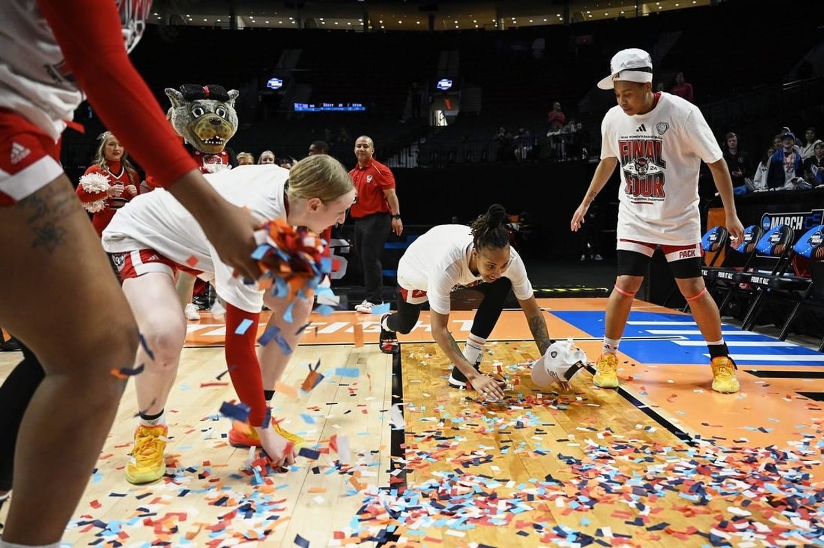 Mar 31, 2024; Portland, OR, USA; NC State Wolfpack guard Aziaha James (10) slides in confetti with teammates, forward Maddie Cox (11) and guard Zoe Brooks (35) in celebration after a game against the Texas Longhorns in the finals of the Portland Regional of the NCAA Tournament at the Moda Center center.