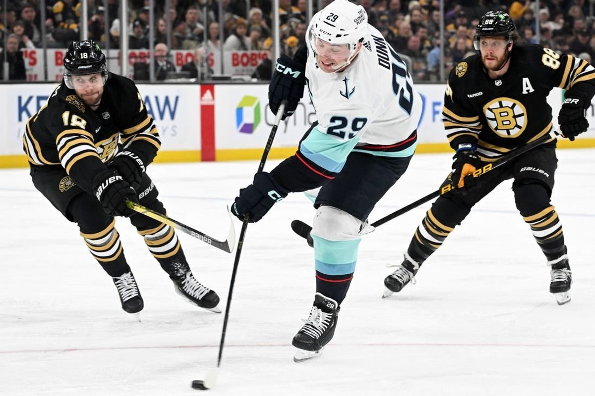 Feb 15, 2024; Boston, Massachusetts, USA; Seattle Kraken defenseman Vince Dunn (29) takes a shot in front of Boston Bruins center Pavel Zacha (18) during the second period at the TD Garden.