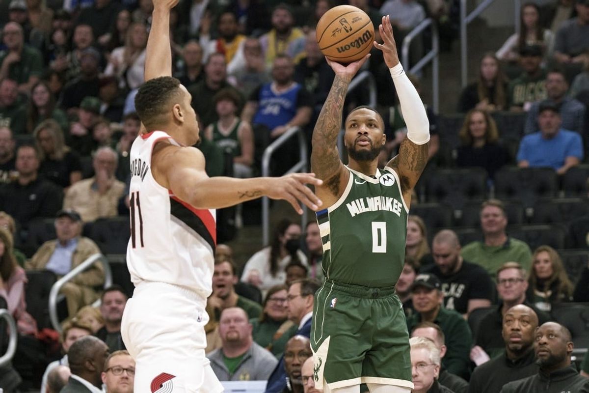 Nov 26, 2023; Milwaukee, Wisconsin, USA;  Milwaukee Bucks guard Damian Lillard (0) shoots against Portland Trail Blazers guard Malcolm Brogdon (11) during the first quarter at Fiserv Forum.