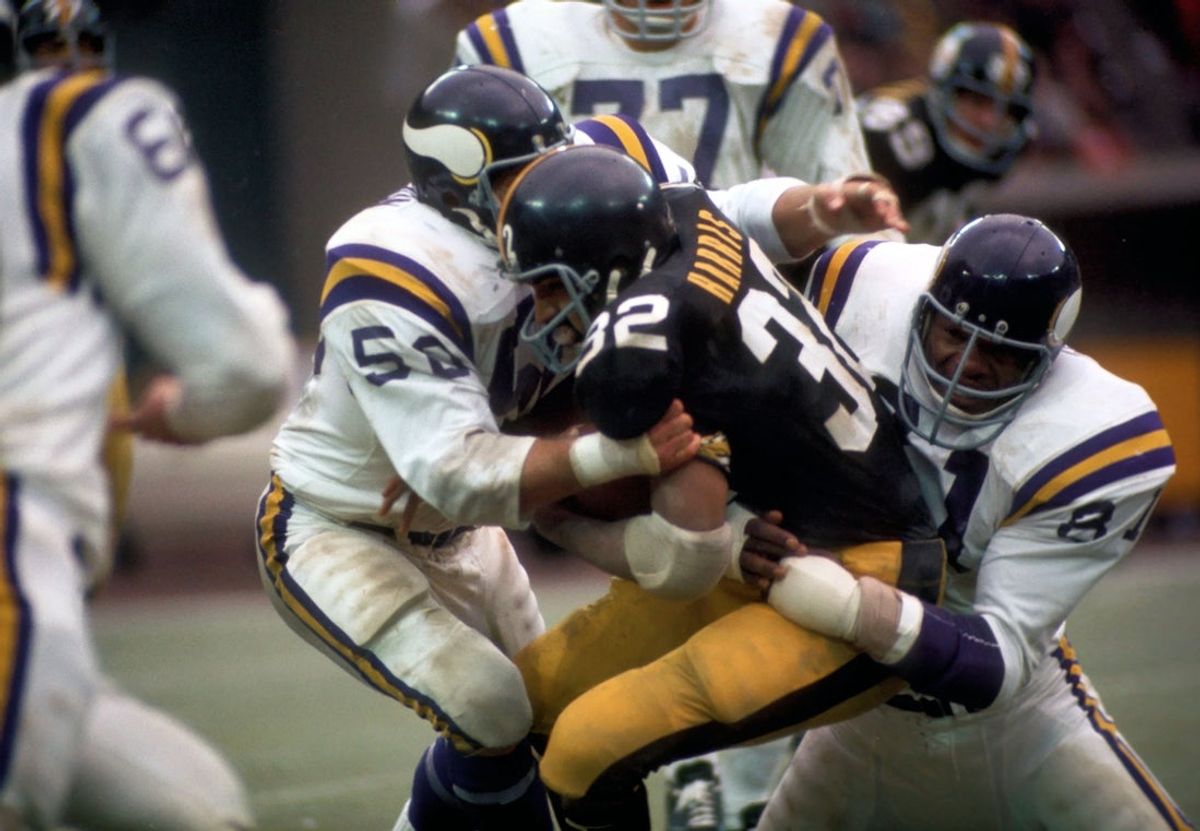 Nov 26, 1972; Pittsburgh, PA, USA; FILE PHOTO; Pittsburgh Steelers running back (32) Franco Harris is hit by Minnesota Vikings defensive end (81) Carl Eller and linebacker (50) Jeff Siemon at Three Rivers Stadium. The Steelers defeated the Vikings 23-10. Mandatory Credit: Tony Tomsic-USA TODAY NETWORK