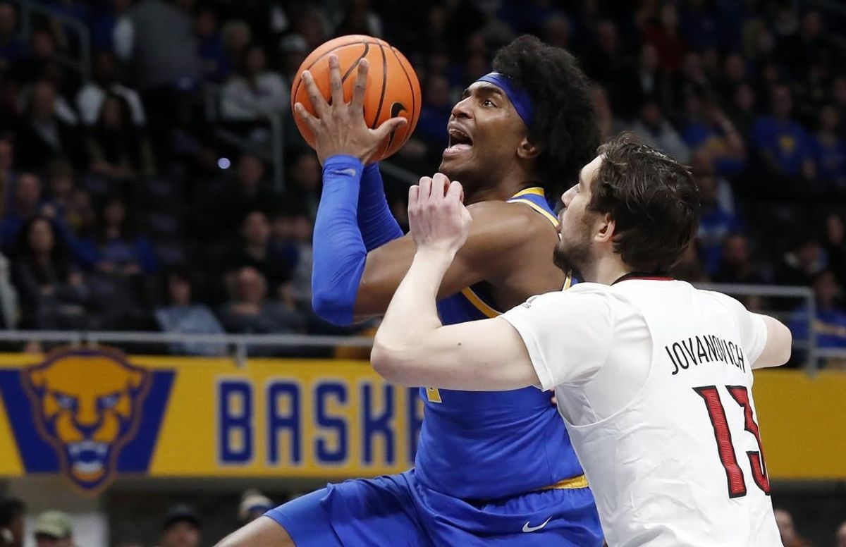 Feb 17, 2024; Pittsburgh, Pennsylvania, USA;  Pittsburgh Panthers forward Blake Hinson (left) goes to the basket against Louisville Cardinals forward Danilo Jovanovich (13) during the first half at the Petersen Events Center.