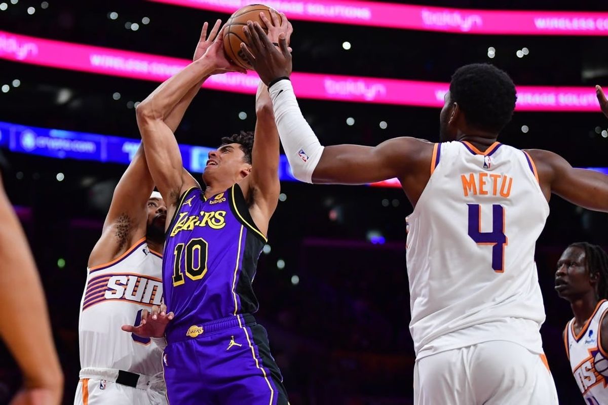 Jan 11, 2024; Los Angeles, California, USA; Los Angeles Lakers guard Max Christie (10) moves to the basket against Phoenix Suns guard Jordan Goodwin (0) and forward Chimezie Metu (4) during the second half at Crypto.com Arena.