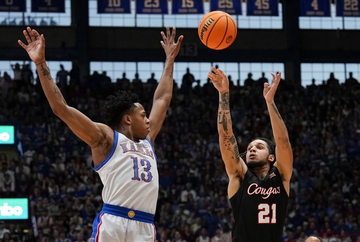 Feb 3, 2024; Lawrence, Kansas, USA; Houston Cougars guard Emanuel Sharp (21) shoots against Kansas Jayhawks guard Elmarko Jackson (13) during the first half at Allen Fieldhouse.