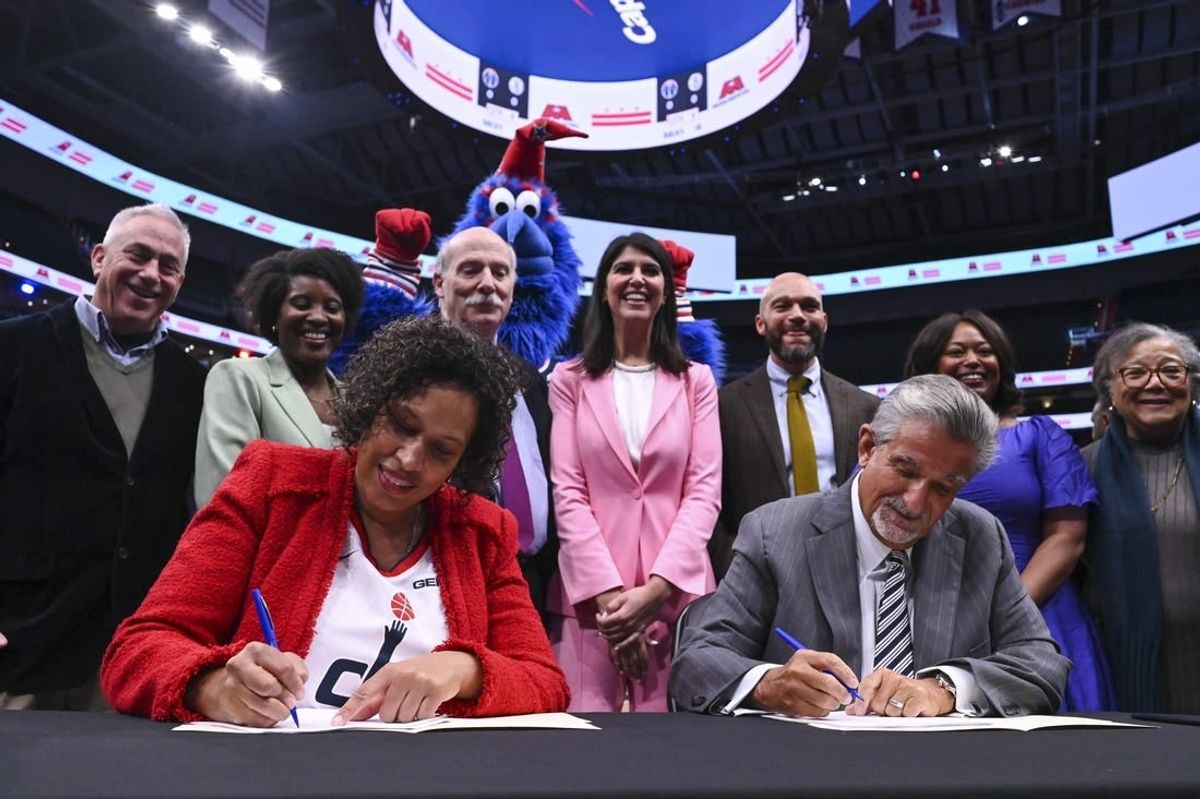 Mar 27, 2024; Washington, District of Columbia, USA;  Washington DC mayor Muriel Bowser  and Monumental Sports & Entertainment CEO Ted Leonsis sign an agreement on the court before the game between the Brooklyn Nets and the Washington Wizards at Capital One Arena.