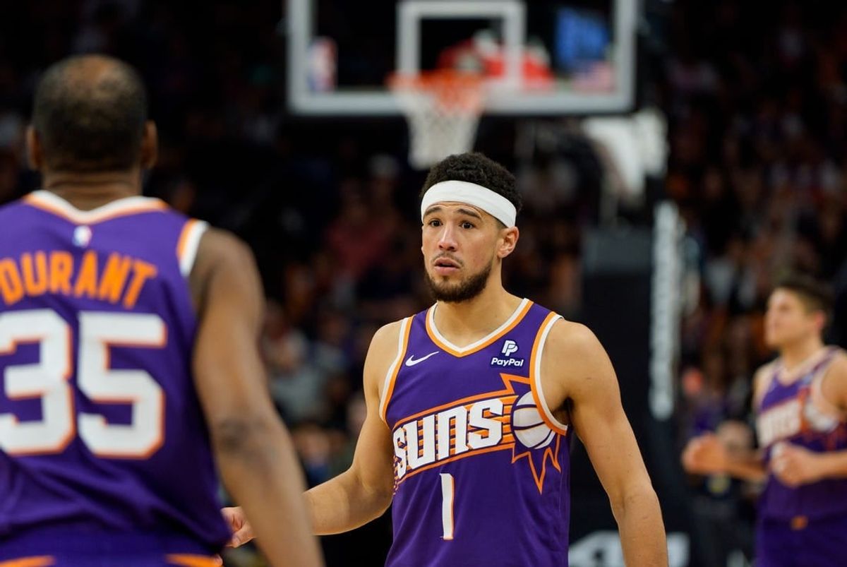 Apr 7, 2024; Phoenix, Arizona, USA;  Phoenix Suns guard Devin Booker (1) and forward Kevin Durant (35) react between plays against the New Orleans Pelicans in the second half at Footprint Center.