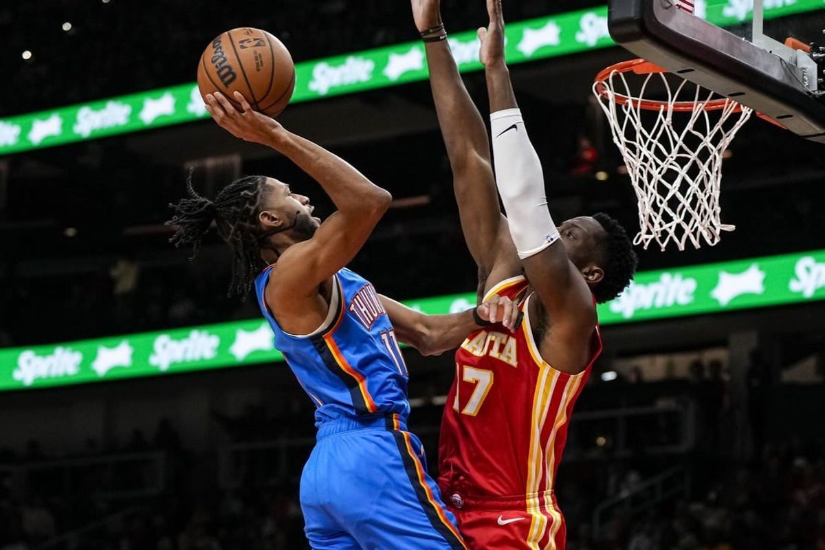 Jan 3, 2024; Atlanta, Georgia, USA; Oklahoma City Thunder guard Isaiah Joe (11) shoots against Atlanta Hawks forward Onyeka Okongwu (17) during the first half at State Farm Arena.