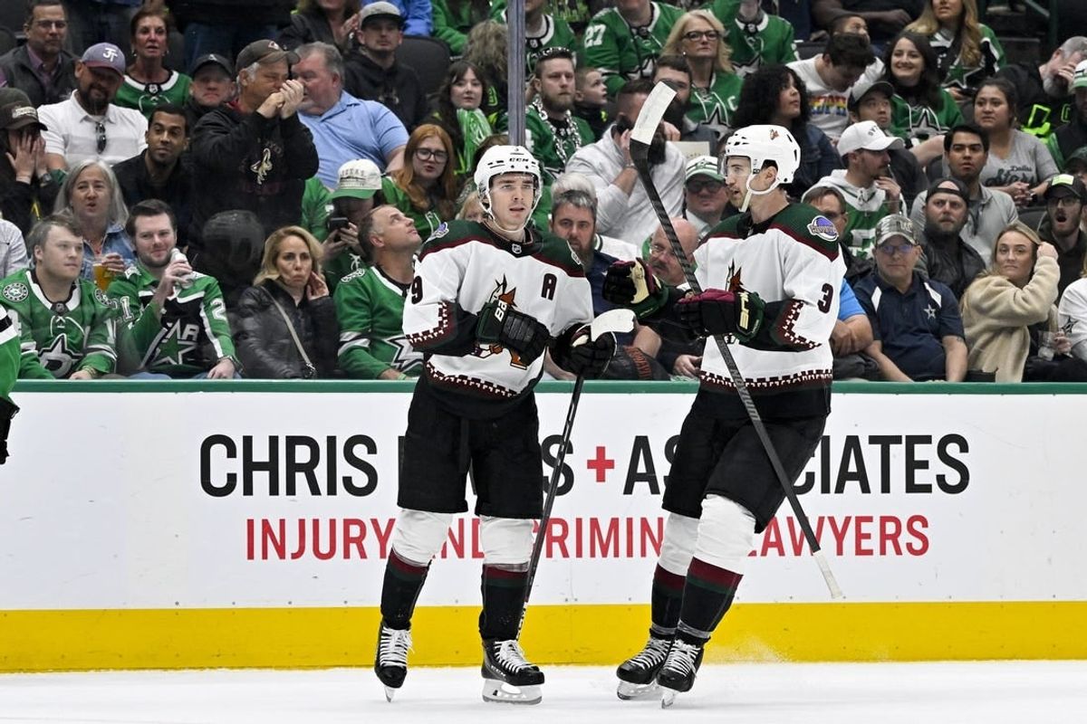 Mar 20, 2024; Dallas, Texas, USA; Arizona Coyotes right wing Clayton Keller (9) and defenseman Josh Brown (3) celebrates a goal scored by Keller against the Dallas Stars during the first period at the American Airlines Center.