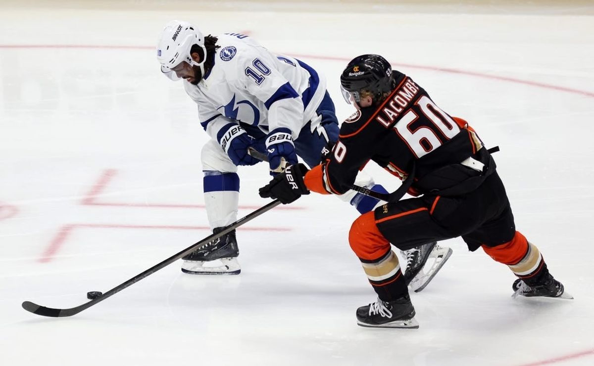 Mar 24, 2024; Anaheim, California, USA; Tampa Bay Lightning left wing Anthony Duclair (10) and Anaheim Ducks defenseman Jackson LaCombe (60) chase the puck during the third period at Honda Center.