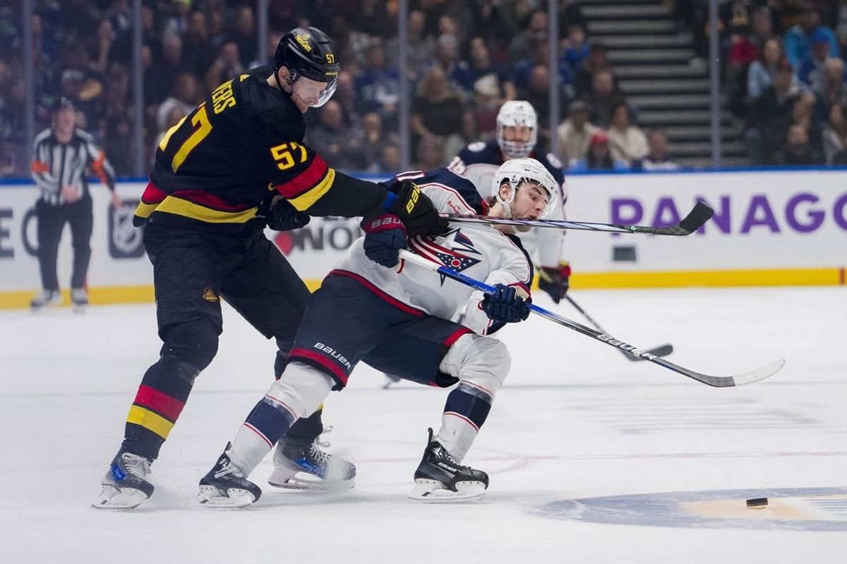 Jan 27, 2024; Vancouver, British Columbia, CAN; Vancouver Canucks defenseman Tyler Myers (57) checks Columbus Blue Jackets forward Adam Fantilli (11) in the third period at Rogers Arena. Canucks won 5-4 in overtime.